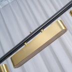 Close view of a brushed brass diffuser and the black bar on this Clérachic pendant, with the slatted light panel on the underside.