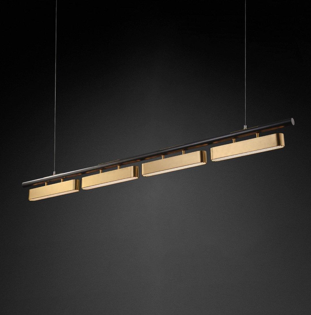 A four-head Clérachic linear pendant on a dark backdrop, its brass diffusers lit along the underside of a slim black bar.