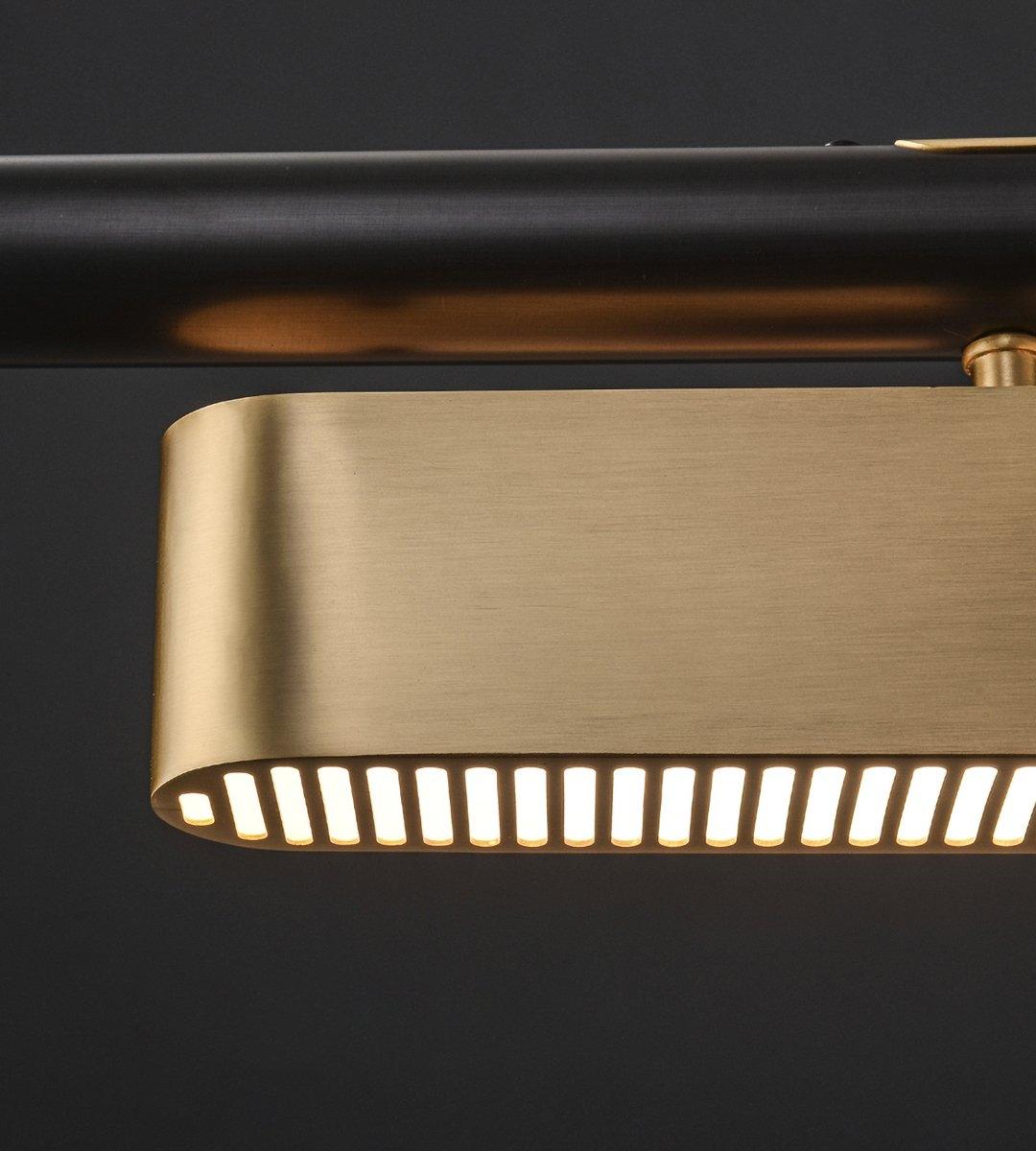 Close view of a brass diffuser on this Clérachic pendant, showing the row of narrow lit slots along its lower edge.
