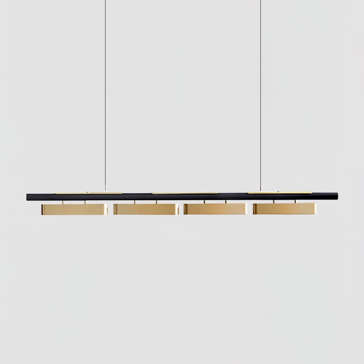 A four-head Clérachic linear pendant on a plain light grey backdrop, with brass diffusers under a slim black bar.