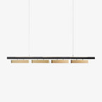 Clérachic four-head linear pendant on a pale backdrop, shown straight on with brass diffusers below the black bar.
