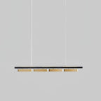 Four-head Clérachic linear pendant against a mid-grey backdrop, with brass diffusers beneath a slim black bar.
