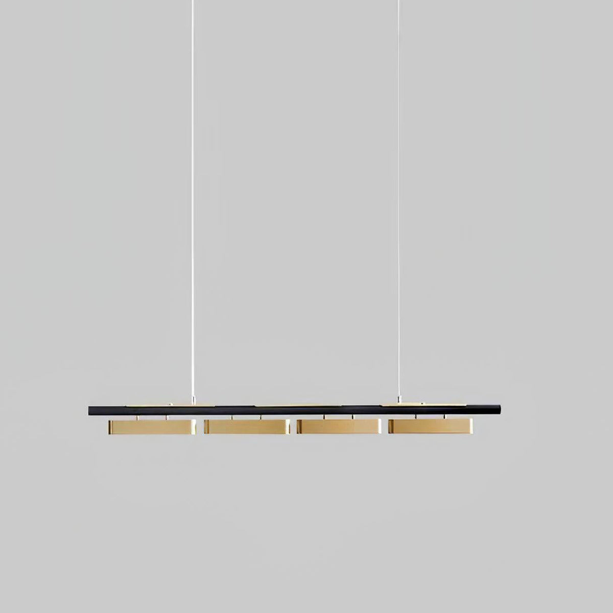 Four-head Clérachic linear pendant against a mid-grey backdrop, with brass diffusers beneath a slim black bar.