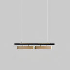 Two-head Clérachic linear pendant on a grey backdrop, with two longer brass diffusers beneath the black bar.