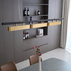 Close view of the Clérachic three-head pendant, with its brass diffusers aligned along a black bar above a shelf of bottles.