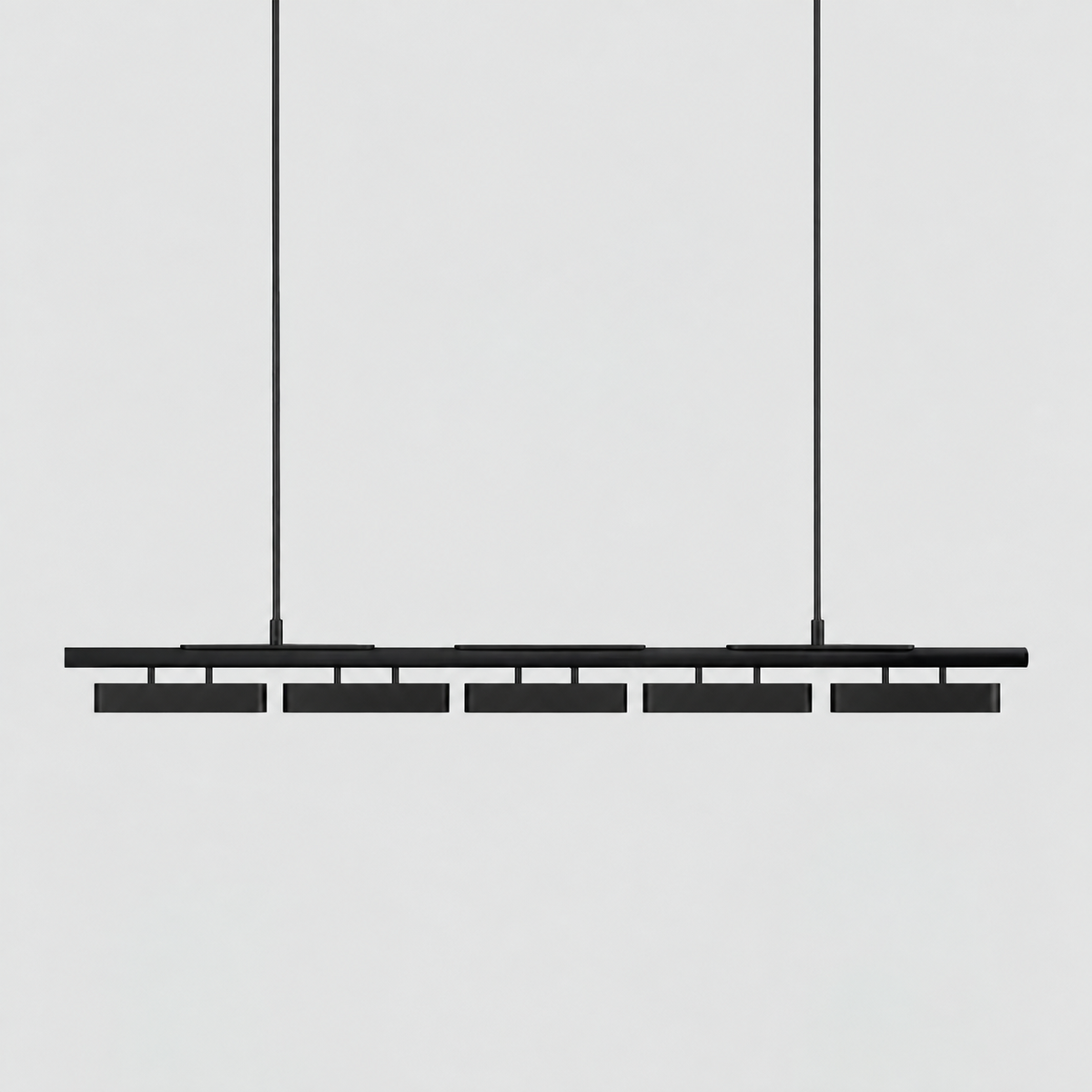 A five-head Clérachic linear pendant in all black, hung on two stiff rods against a pale grey backdrop.