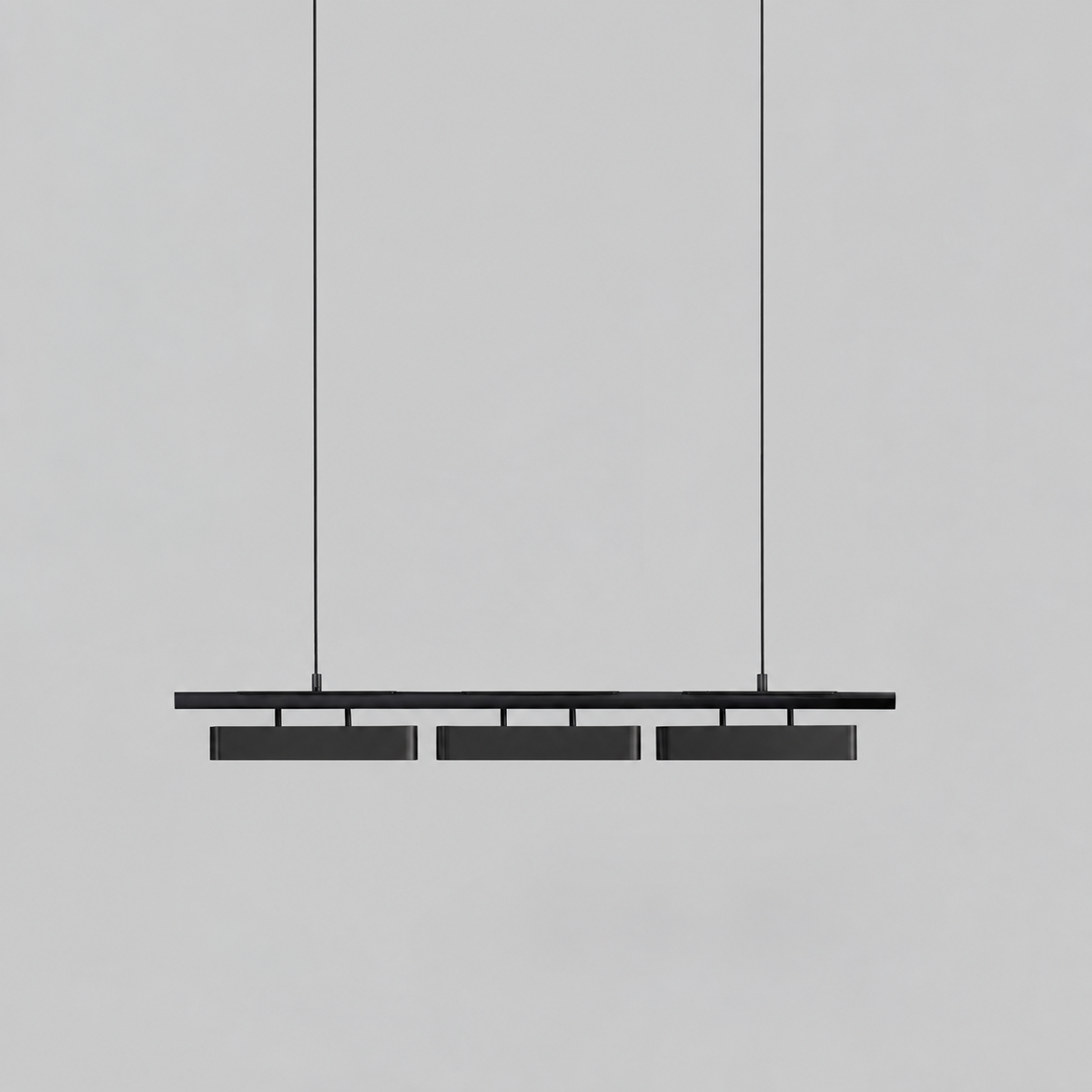 All-black three-head Clérachic linear pendant against a mid-grey backdrop, hung on two thin wires.