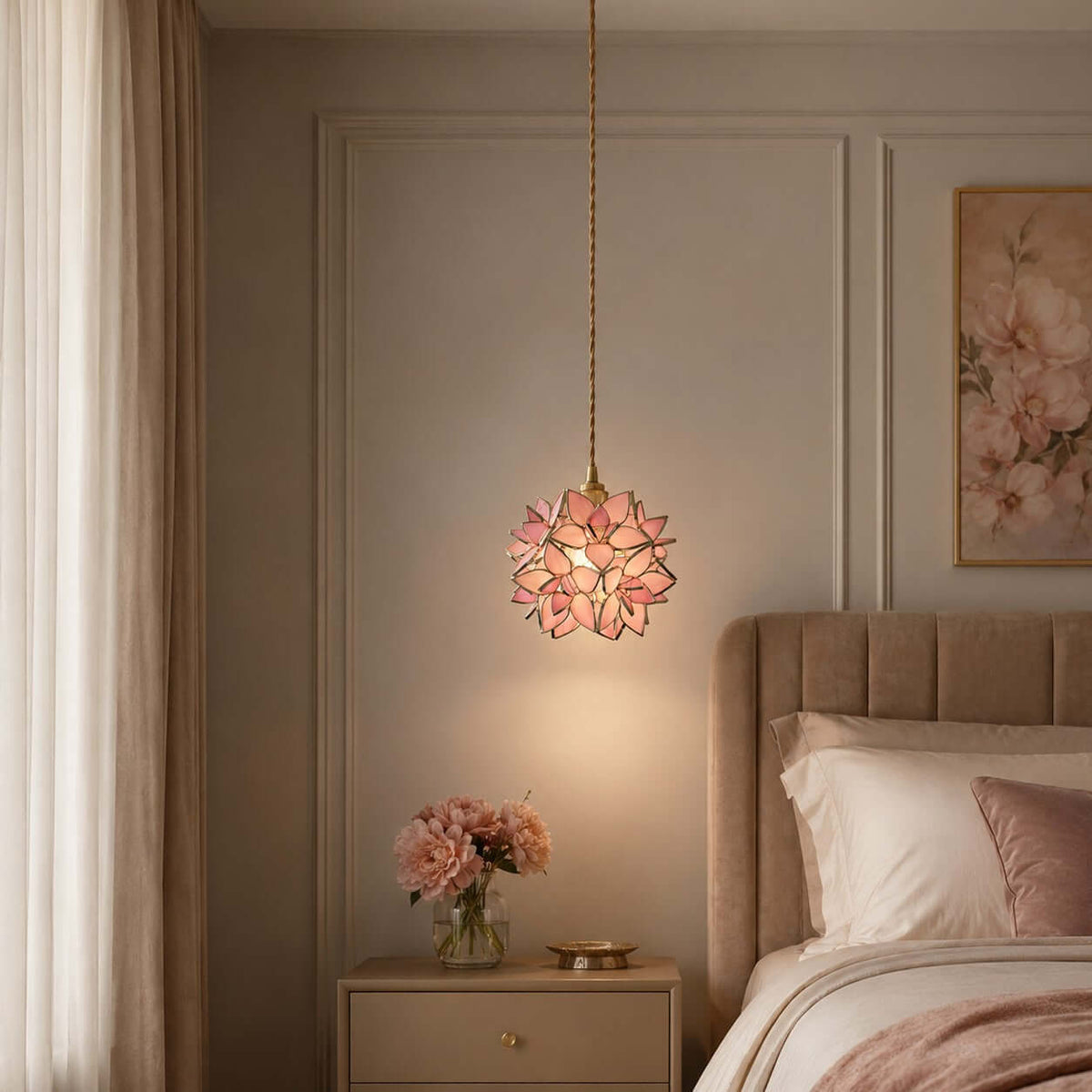 A pink petal Clérachic pendant glows beside a bed with a taupe headboard and a small vase of peonies on the bedside table.
