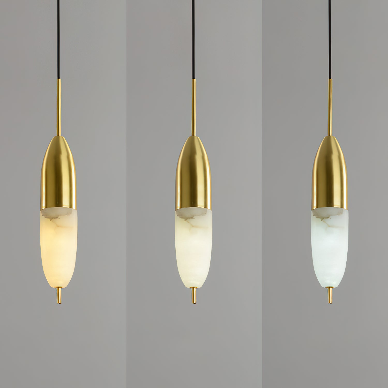 Three slim Clérachic Brass Pendant Lights, LED colour stepping from warm gold through cooler white.