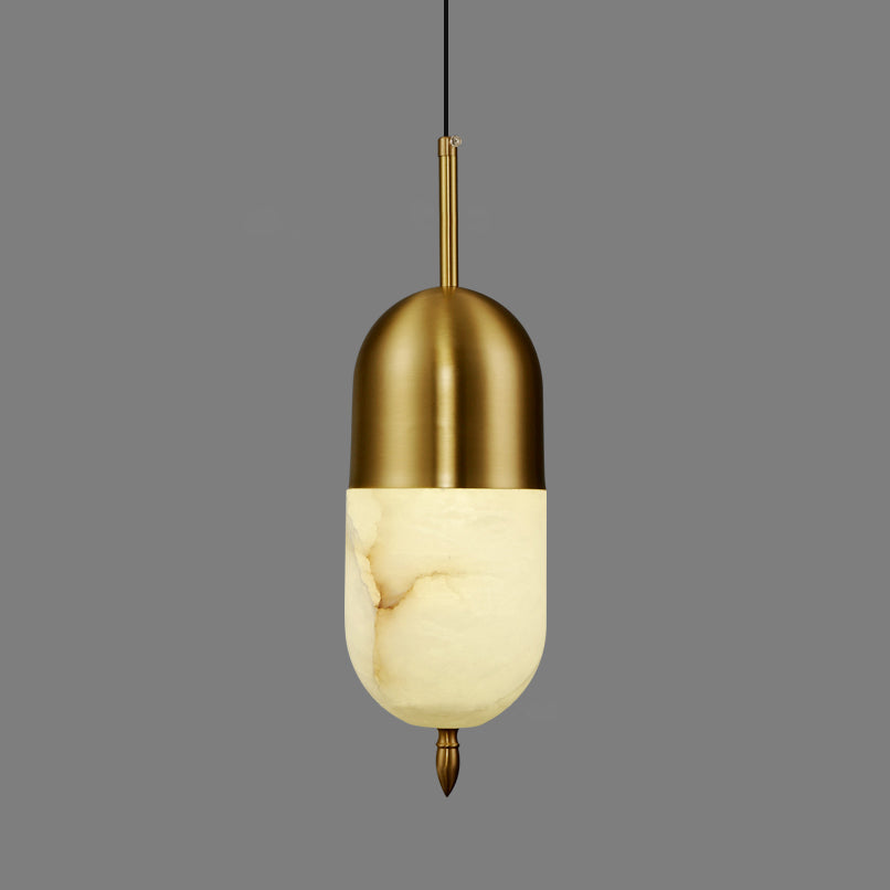 Clérachic Brass Pendant Light in the shorter capsule shape, brass dome over glowing Spanish alabaster on grey.