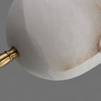 Brushed brass cuff meeting veined Spanish alabaster on the Clérachic Brass Pendant Light, tan mottling on the stone.