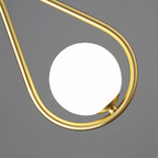 Close view of the Clérachic brass teardrop frame and its lit opal glass globe, showing the satin brass finish and the small clasp.