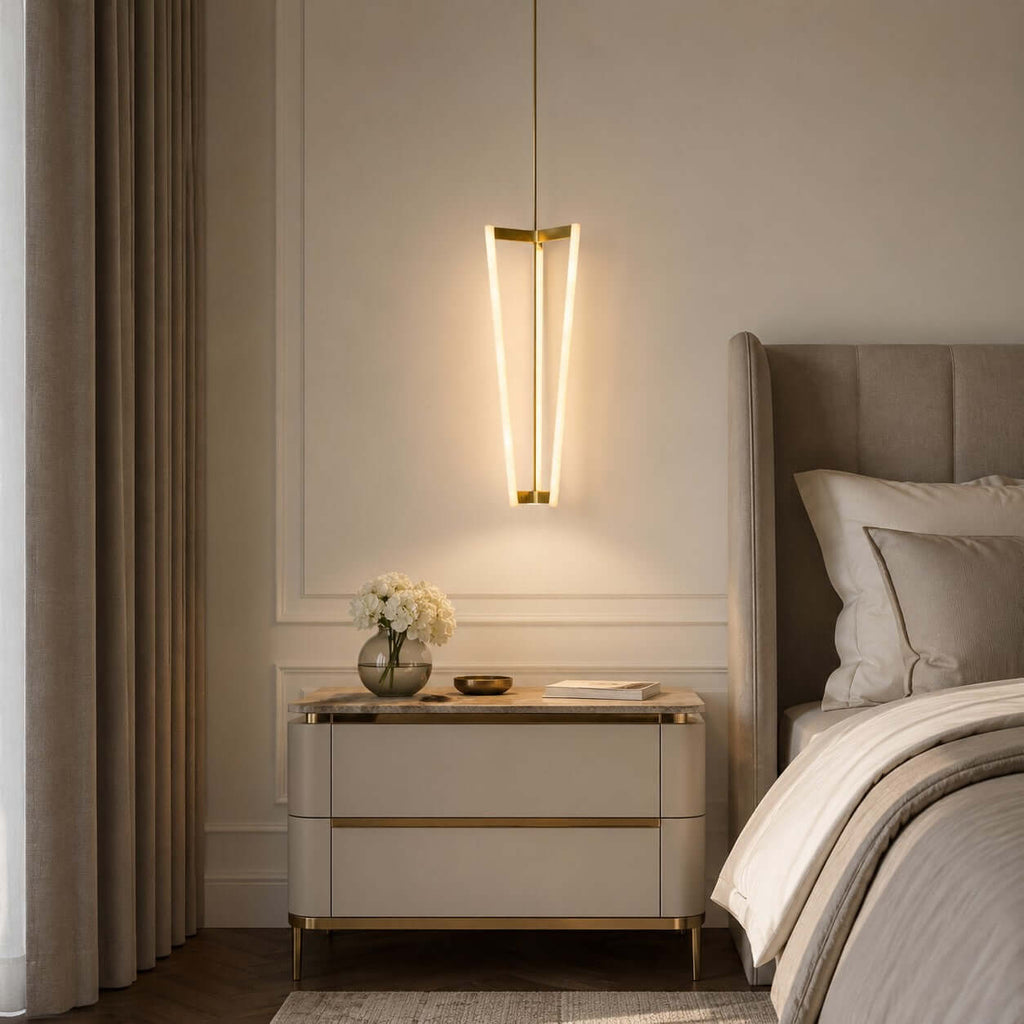 Hung beside a bed and a cream bedside chest, this Clérachic pendant lights a panelled bedroom wall with three slim glowing tubes.
