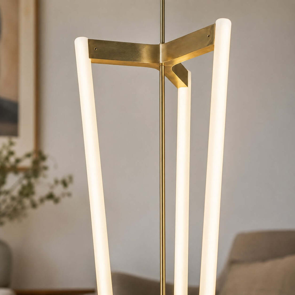 Close view of the brass bracket on this Clérachic pendant, where three frosted LED tubes meet at the central rod.