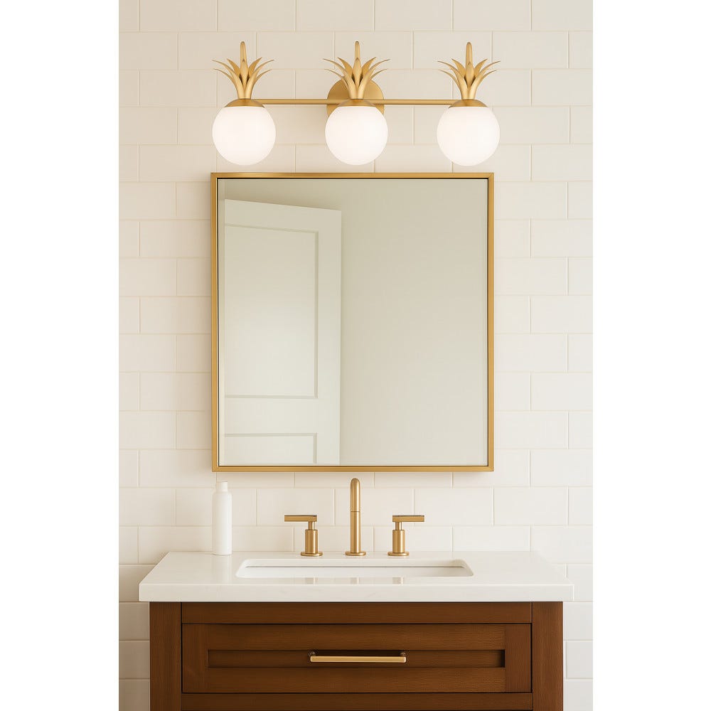Three-light Clérachic wall light above a gold-framed mirror in a tiled bathroom, with a walnut vanity and brass taps below.
