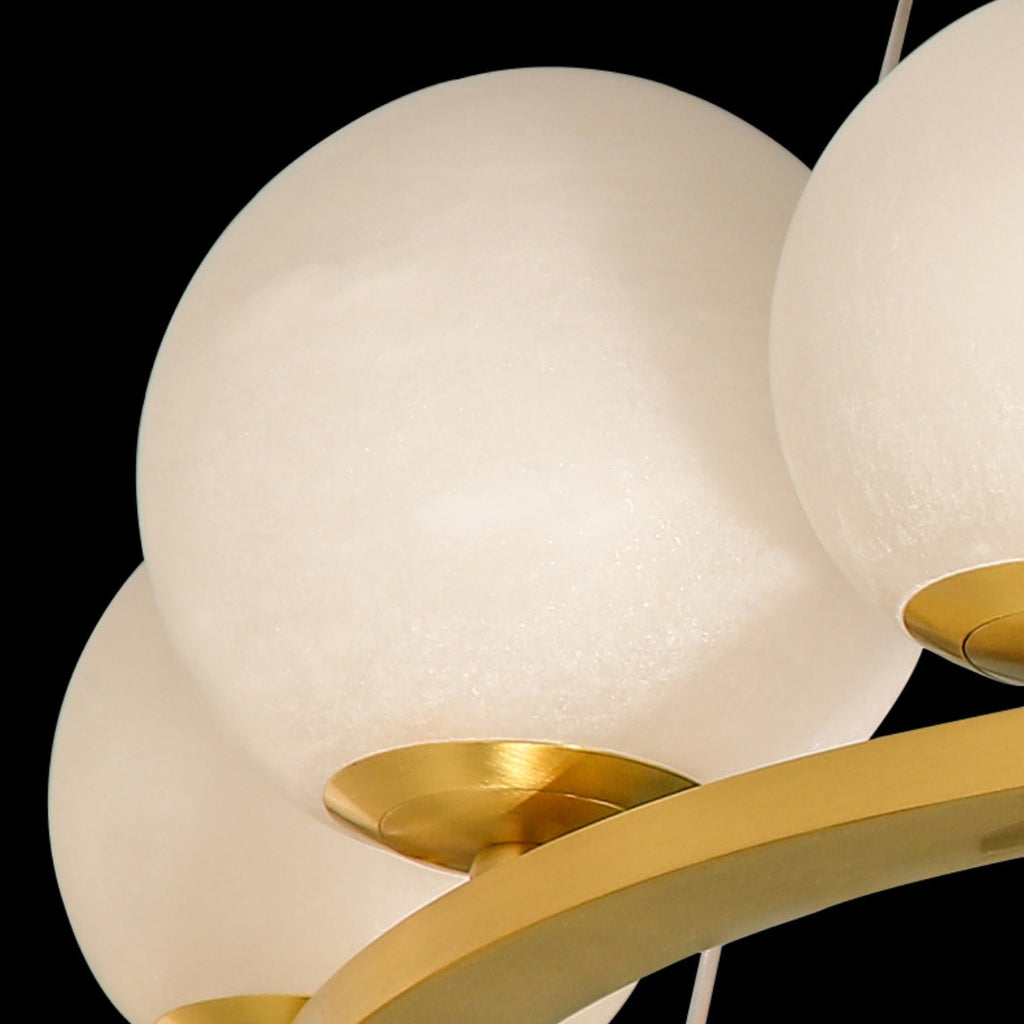 Detail of two Clérachic alabaster globes and the brushed brass cup that holds each one to the ring.