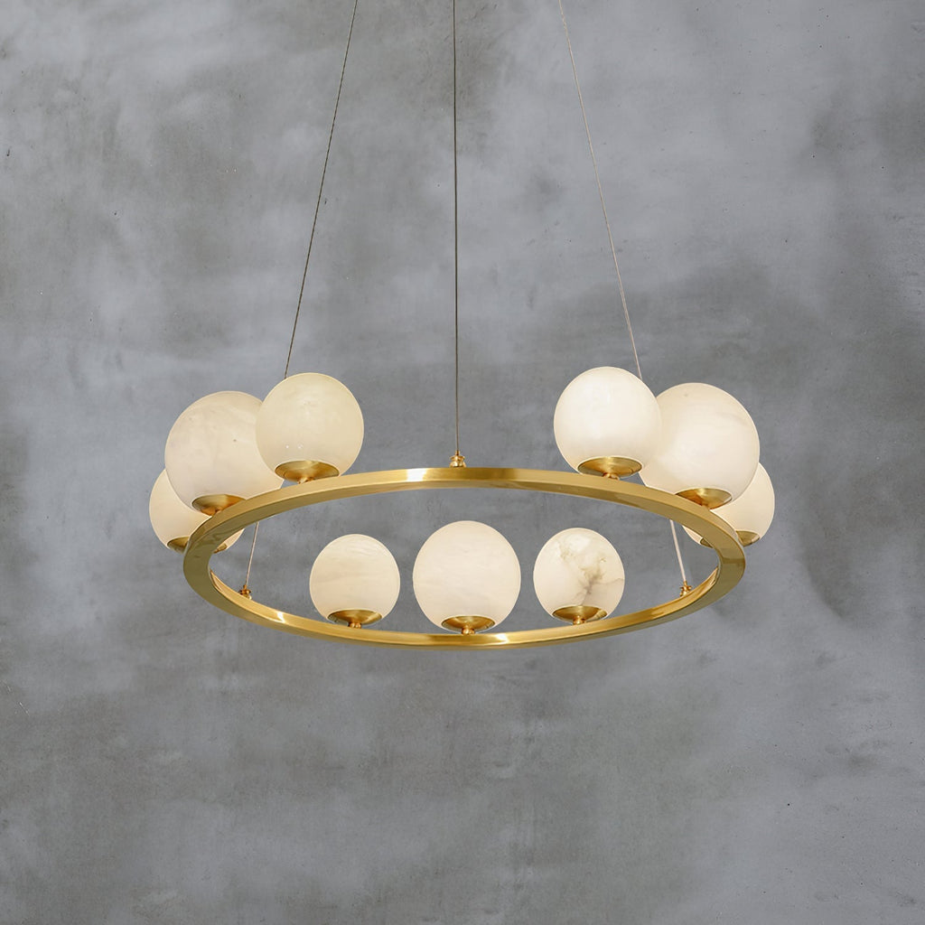The Clérachic chandelier shot from above against a concrete wall, showing the polished brass ring and the two planes of alabaster globes.