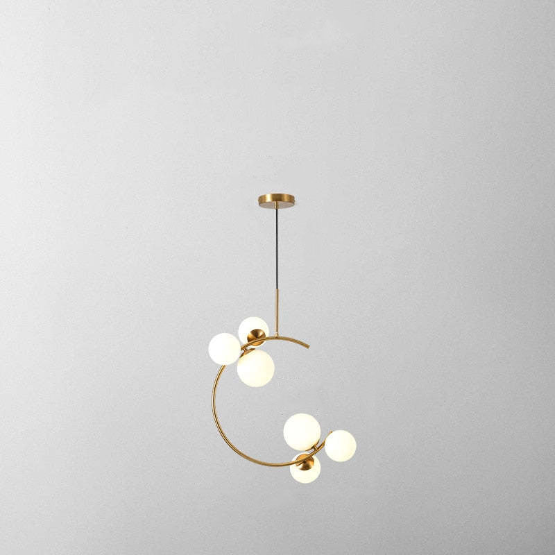 Product shot of the Clérachic brass ring globe pendant in milky white glass, six lit spheres on a plain grey backdrop.