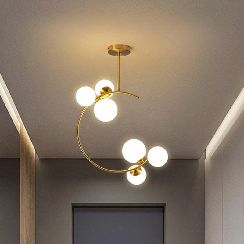 The Clérachic brass ring globe pendant in milky white glass lighting a narrow hallway beside a natural wood ceiling beam.
