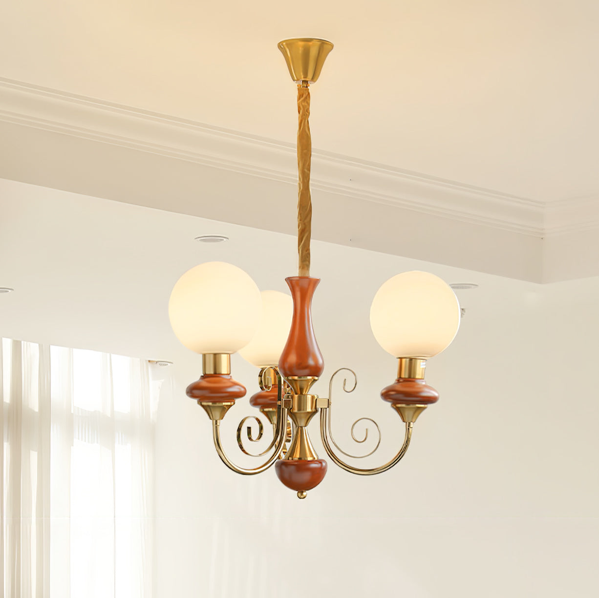Red-brown Clérachic Brass Scrollwork Chandelier with three opal globes lit against a white corniced ceiling.