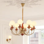 Eight-light Clérachic Brass Scrollwork Chandelier in red-brown, lit above a bright room beside the matching wall light.