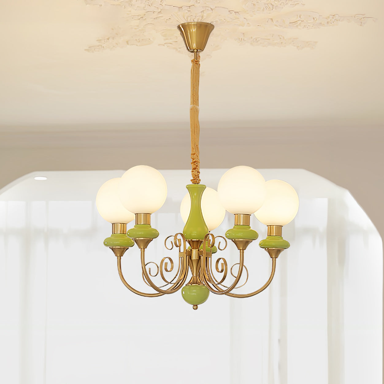 Clérachic Brass Scrollwork Chandelier in green, five lit globes fanning out under a moulded plaster ceiling rose.