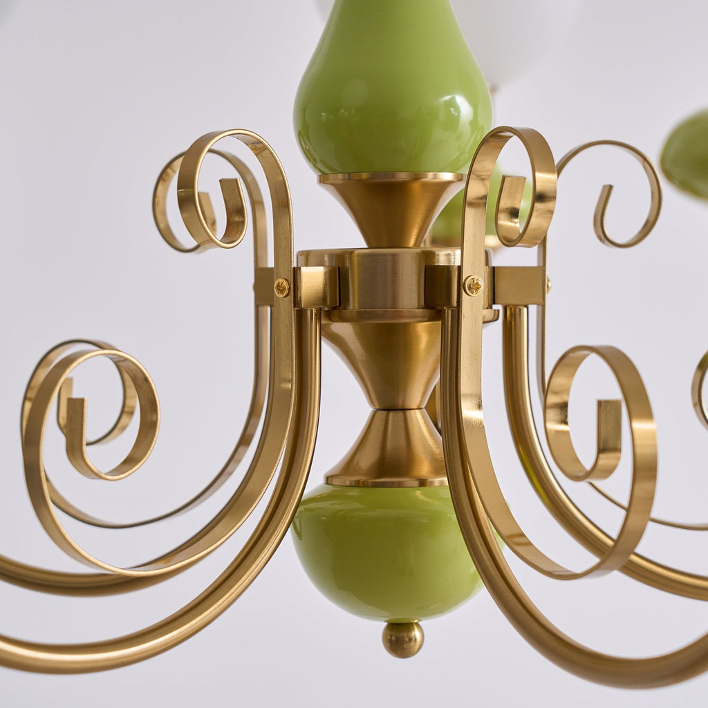 Close view of the Clérachic Brass Scrollwork Chandelier centre column, brass volutes curling around the glossy green stem.