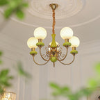 Clérachic Brass Scrollwork Chandelier in green, five lights lit under a plaster ceiling medallion in a tall room.