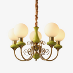 Clérachic Brass Scrollwork Chandelier in green, five lights shown against a soft light backdrop with the flex above.