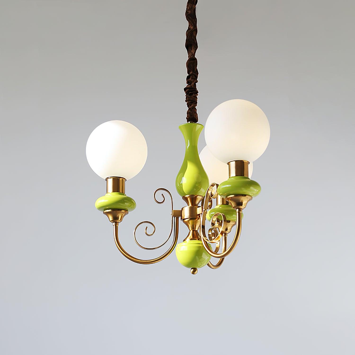 Three-light Clérachic Brass Scrollwork Chandelier in green, shown on a grey backdrop with a dark twisted flex.