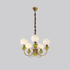 Green Clérachic Brass Scrollwork Chandelier at full drop on grey, brass canopy above five lit opal globes.