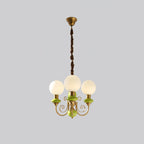 Three-light Clérachic Brass Scrollwork Chandelier in green at full drop, canopy and flex shown on a grey backdrop.