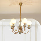 Sage-green Clérachic Brass Scrollwork Chandelier lit under a moulded ceiling rose, five opal globes glowing warm.
