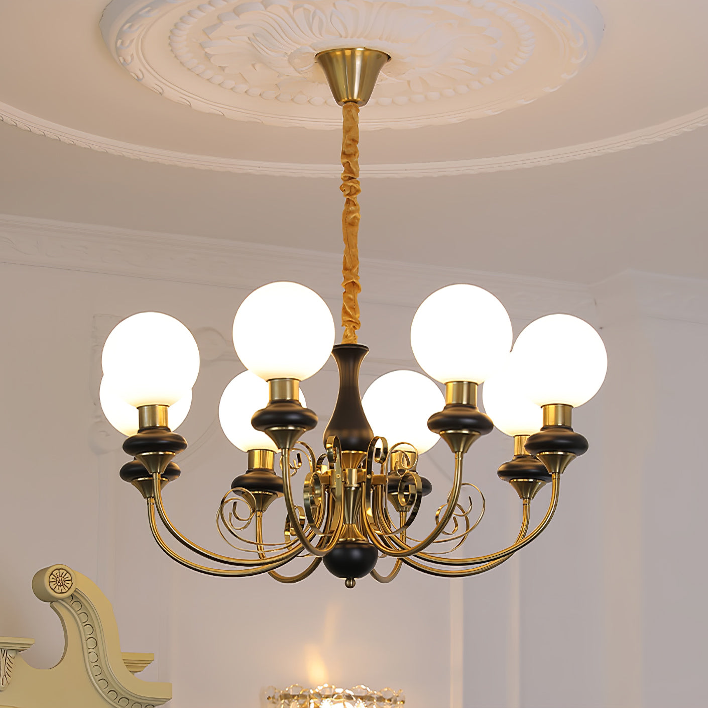 Clérachic Brass Scrollwork Chandelier in black, eight lit globes below a deep round plaster ceiling medallion.