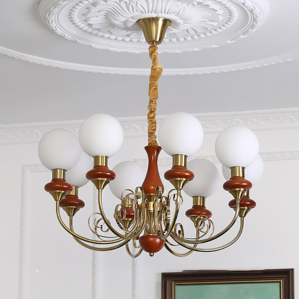 Eight-light Clérachic Brass Scrollwork Chandelier in red-brown, lit directly below a deep round ceiling medallion.