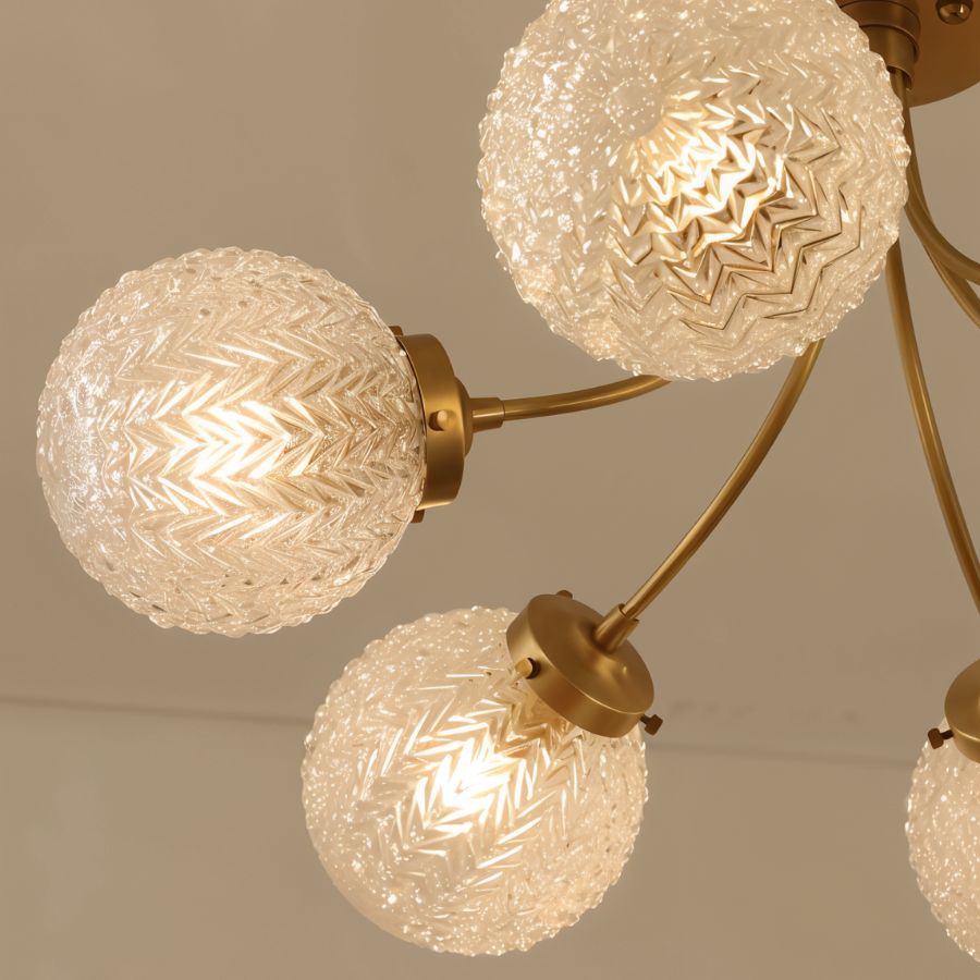 Clérachic close view of brass arms and ribbed herringbone glass globes lit warm, with the brass bulb-holder caps visible.