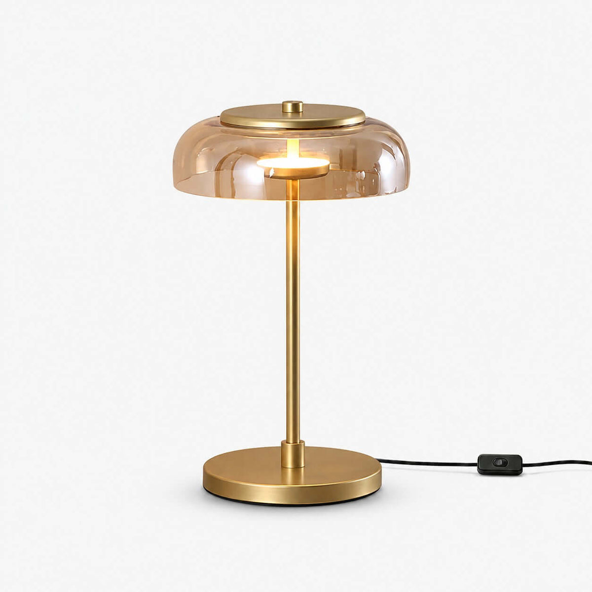 Clérachic table lamp on a white backdrop, an amber glass dome over a slim brass stem and round base, with an in-line switch on the black cord.