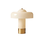 A cream Clérachic table lamp with a glossy domed shade and a brass base, cut out on a plain white backdrop.