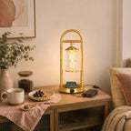 Clérachic table lamp on a wooden console, a phone on its charging pad and a power bank beside it, with a bowl of grapes.