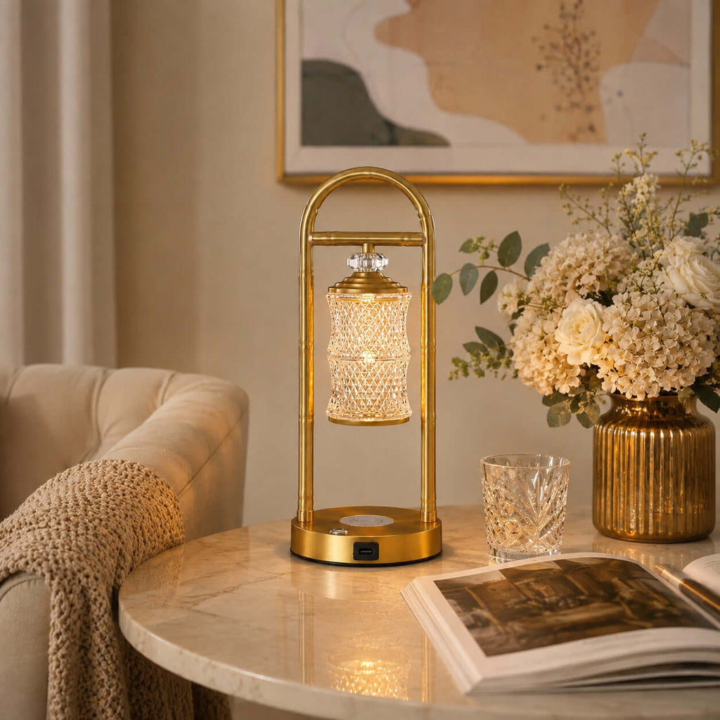 Clérachic table lamp on a round marble side table, with an open book, a crystal glass and a vase of cream hydrangeas.