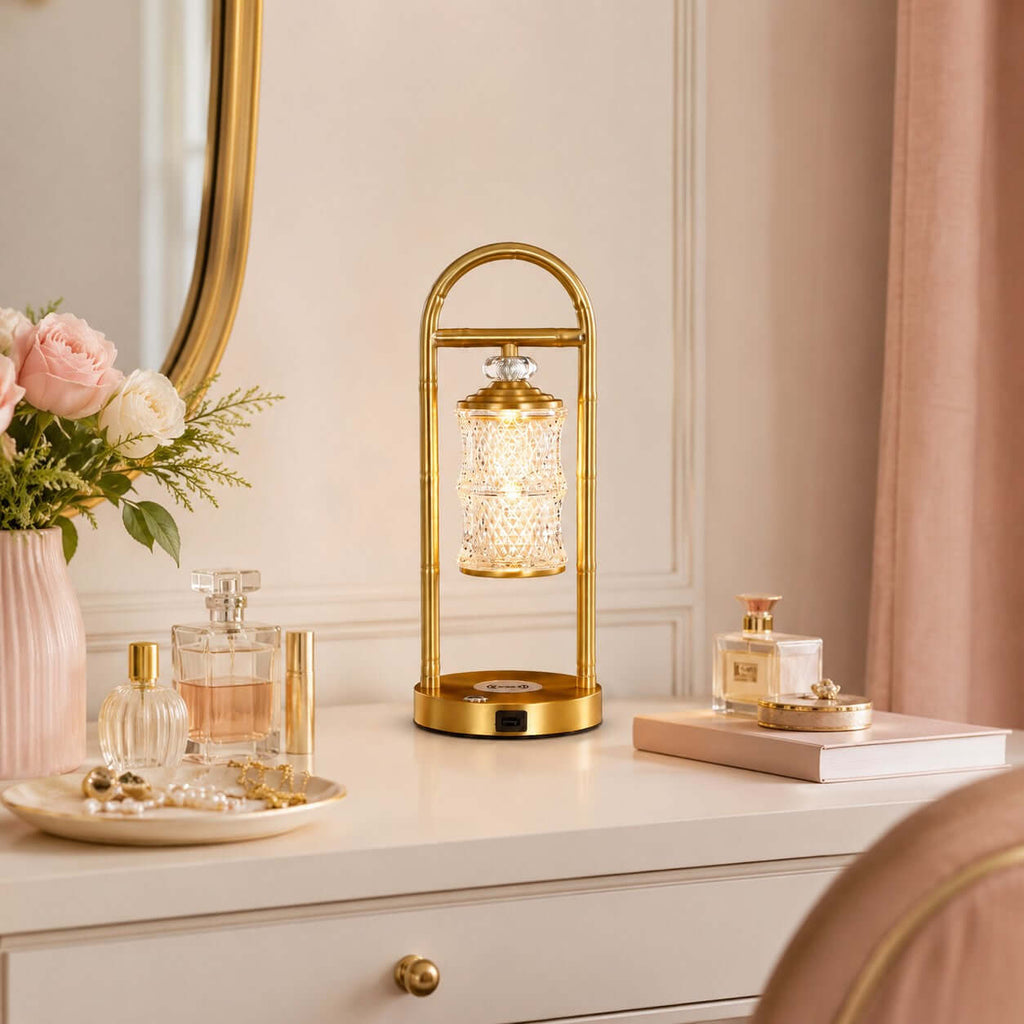Clérachic table lamp on a white dresser beside a gold-framed mirror, with pink roses and a tray of perfume bottles.