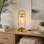 Clérachic table lamp plugged in on a pale wood sideboard, a phone charging on its base and a framed seascape on the wall.