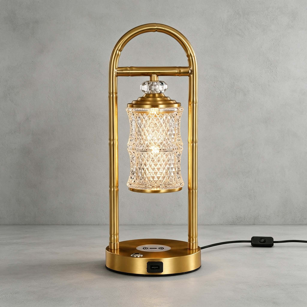 Brass Clérachic table lamp on a grey concrete-look backdrop, its black cord and in-line switch trailing to the right.