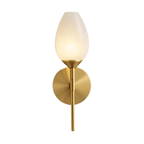 Clérachic brass wall lamp with a tulip-shaped frosted shade, lit warm and cut out on a plain white background.