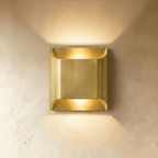 Clérachic largest square brass wall light with rolled edges, warm up and down light washing over limewash.