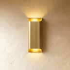 Clérachic tall rectangular brushed brass wall light, 10 × 30 cm, sending warm light up and down a plaster wall.
