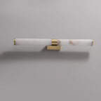 Mounted sideways, this Clérachic alabaster tube light with a brass band and a small wall plate sits on a pale grey wall.
