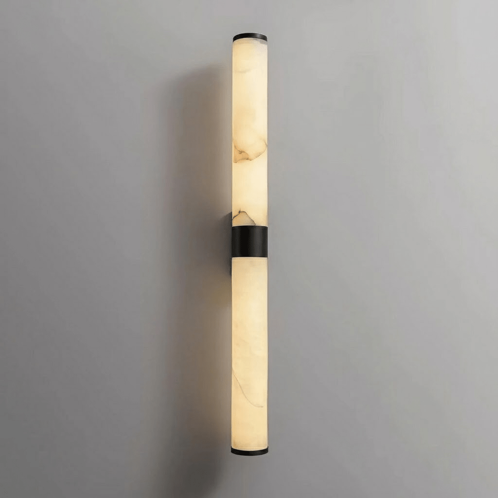 A black-banded alabaster tube wall light with black end caps on a pale grey wall, switched off, from Clérachic.