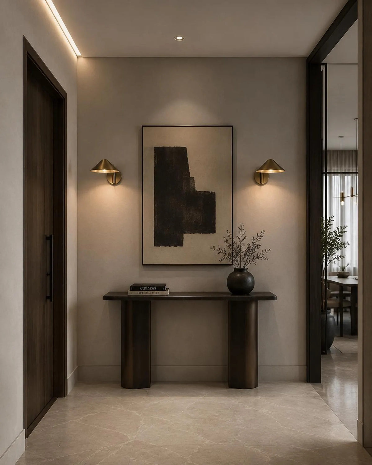 Two Clérachic brass cone-shade wall lights lighting a hallway console and abstract artwork, seen at an angle