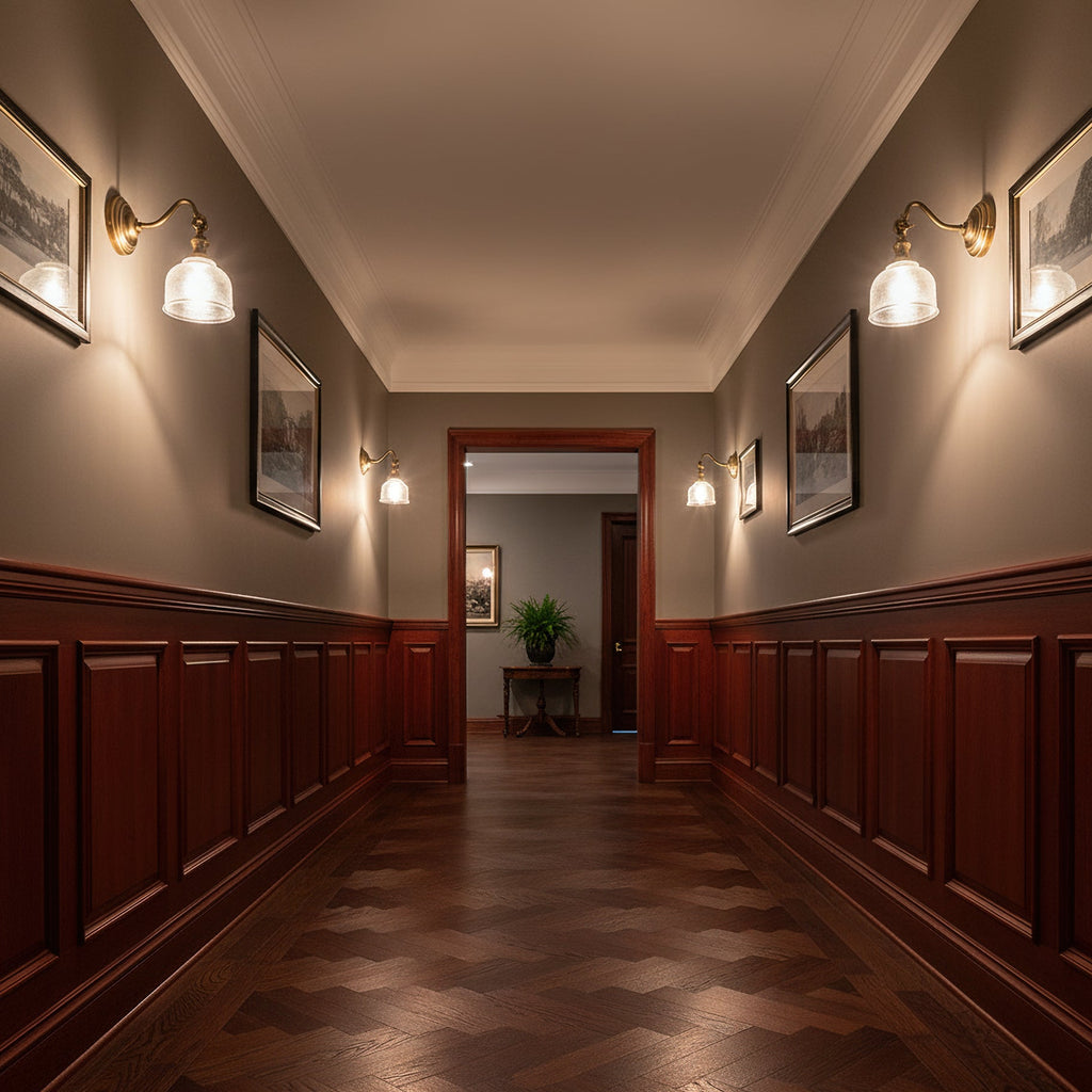 Clérachic brass wall lights with glass shades line both sides of a long hallway with dark wood panelling and a parquet floor.